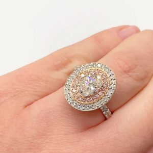 Oval diamond with double halo featuring pink diamonds set in rose gold.