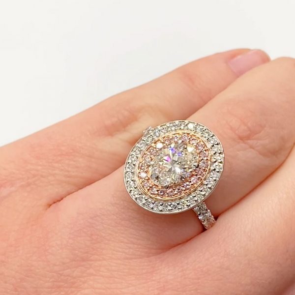 Oval diamond with double halo featuring pink diamonds set in rose gold.