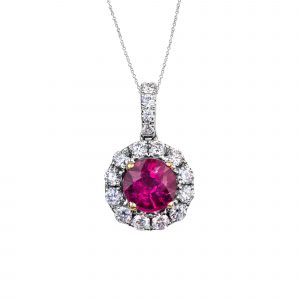 ruby and diamond pendant in 14 karat white gold with claws in 18 karat yellow gold, featuring a round ruby weighing 1.64ct within a surround of round brilliant cut diamonds